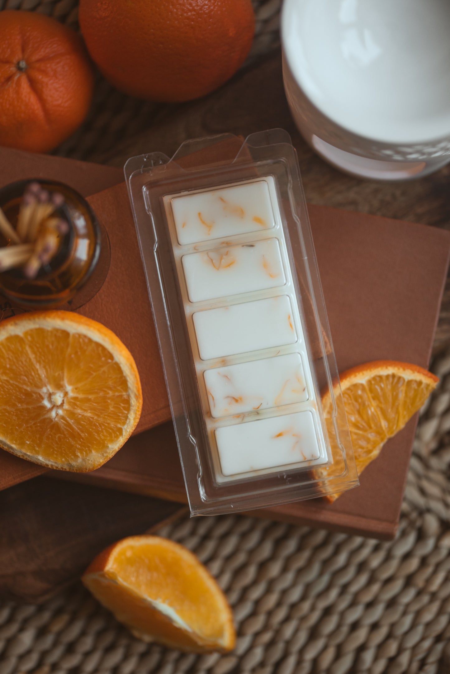 wax melt bar with 5 segments and oranges, whole and sliced around the product 