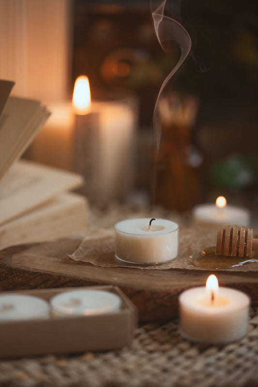 Country style image with tea lights burning and one just blown out