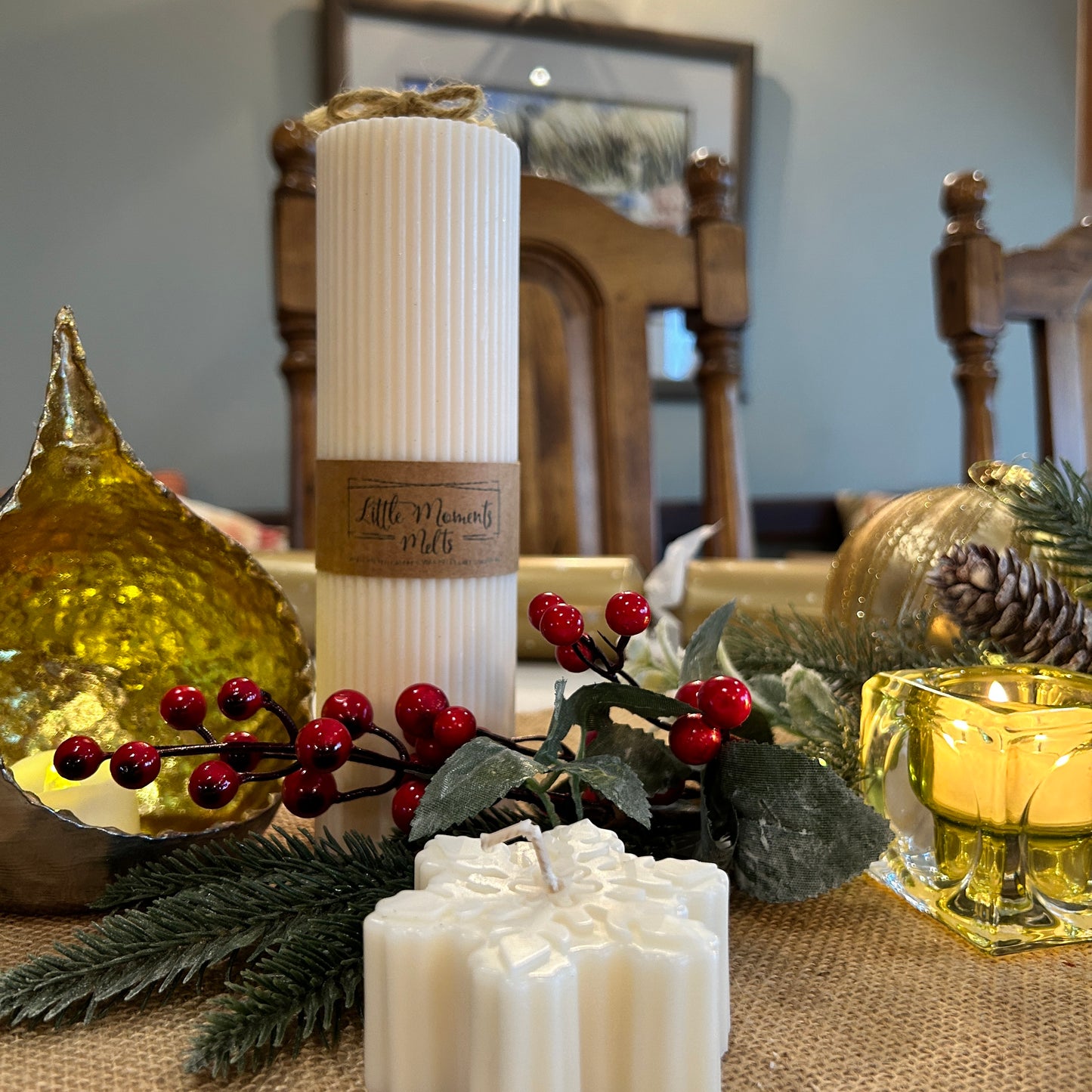 large ribbed pillar candle on a table with a runner, foliage , teardrop candle glow bowl and mini candle 